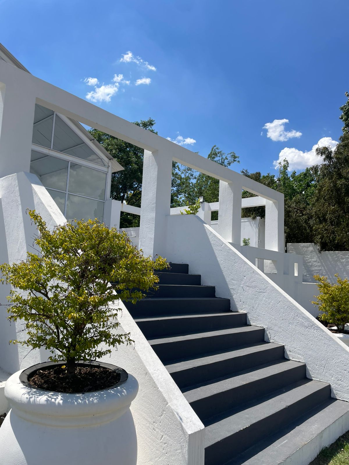 Whitewashed staircase rising to the pavilion under blue sky