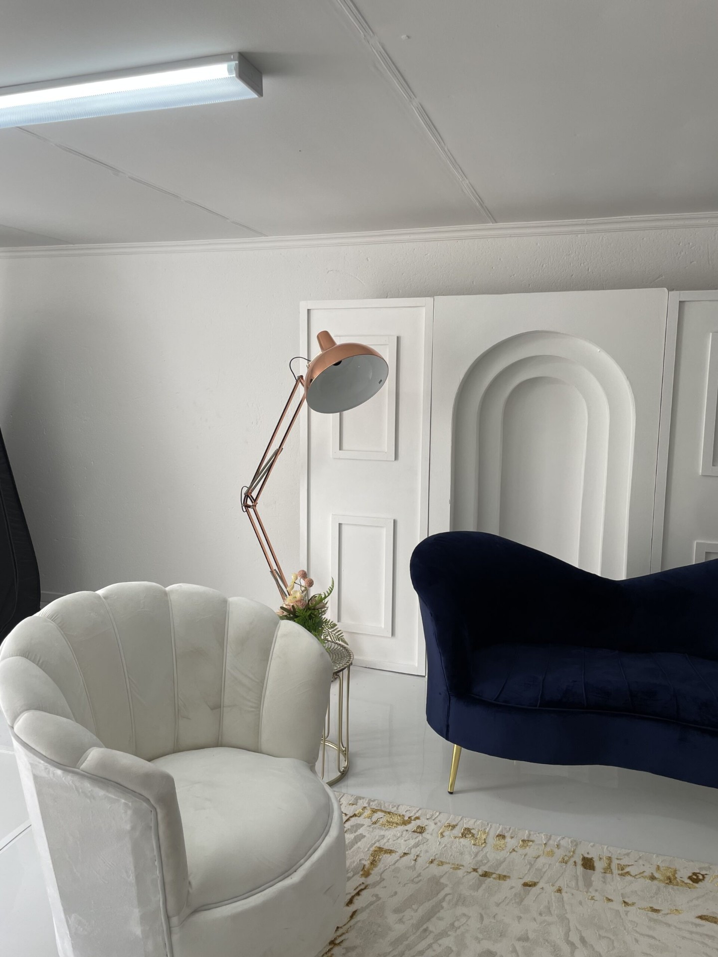 White velvet shell chair and navy chaise inside the styled lounge