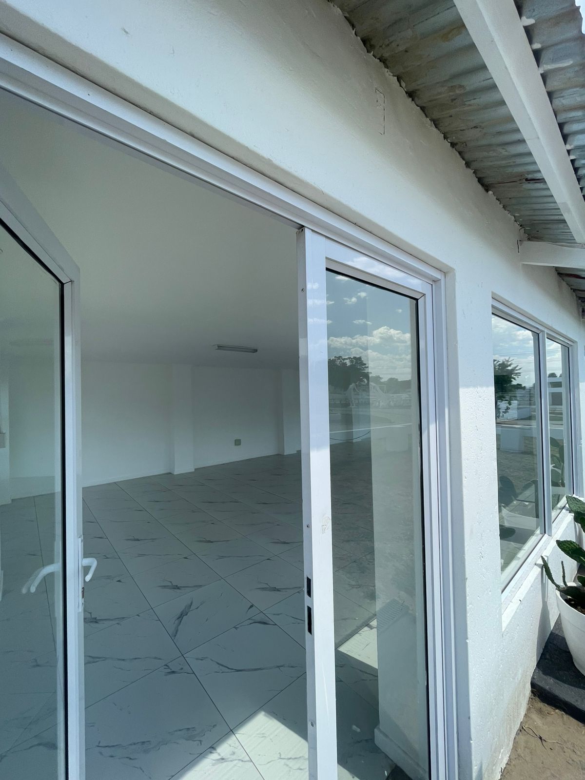 Open-plan hall with marble tile flooring and floor-to-ceiling glass