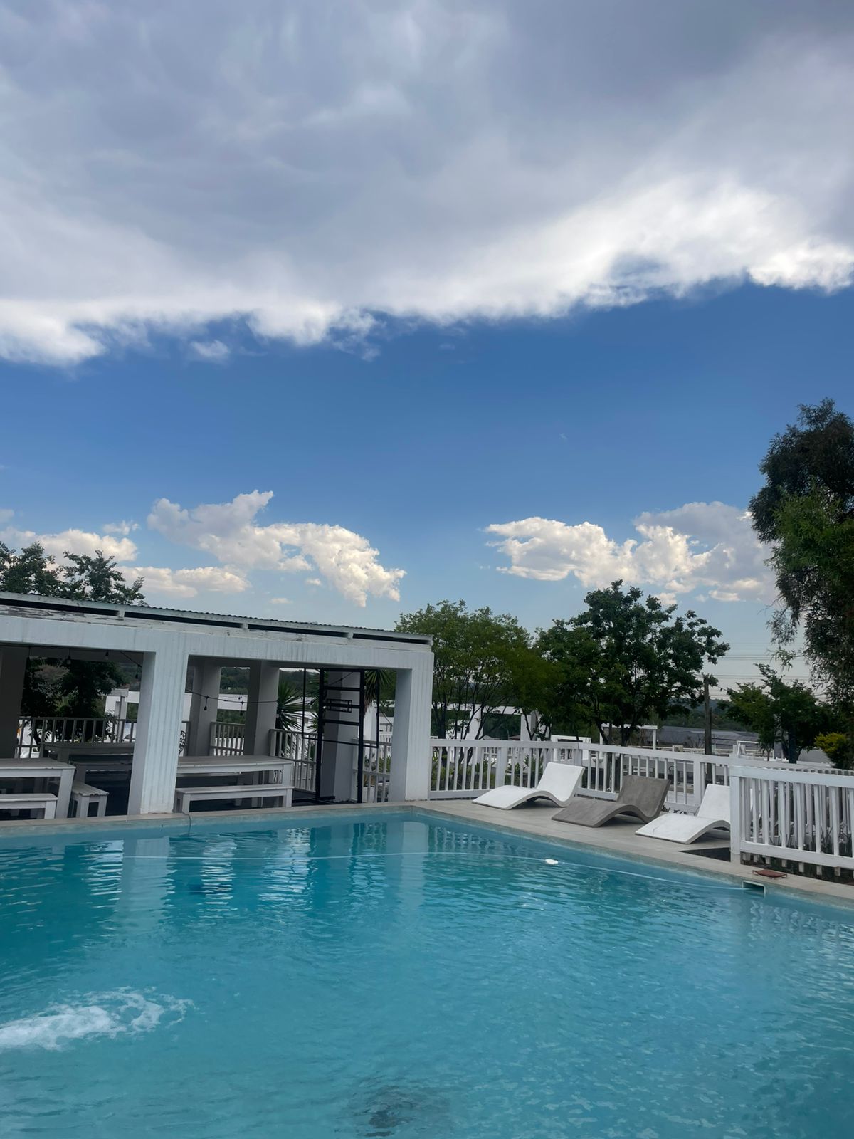 Pool deck and bar pavilion under a wide South African sky