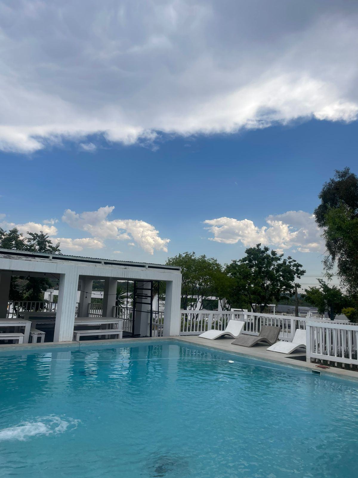 Pool deck and bar pavilion under a wide South African sky